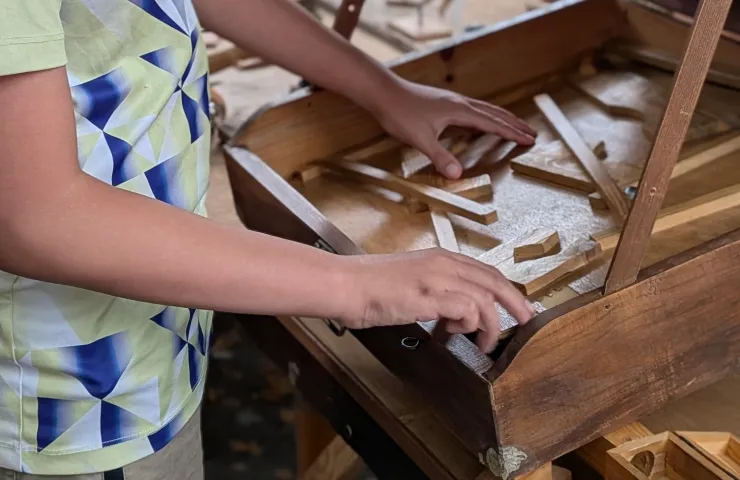 detalle de manos de un niño jugando con unas piezas de madera
