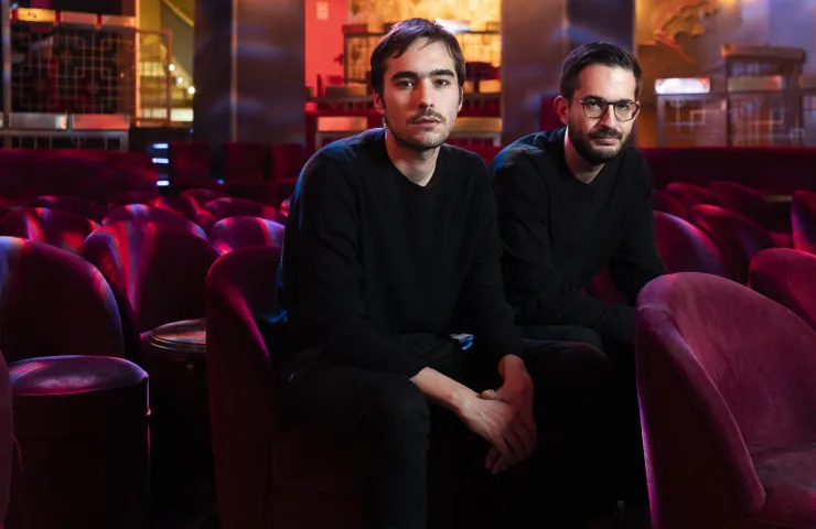 los dos componentes del grupo sentado en un patio de butacas de cualquier teatro, ambos vestidos de negro