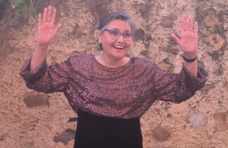 mujer sonriendo con los brazos levantados